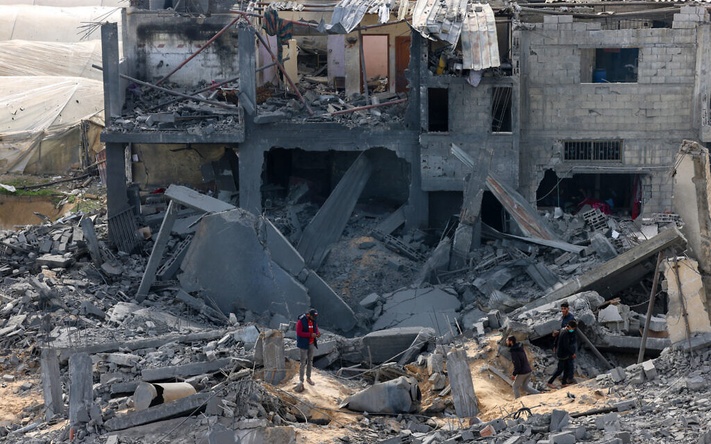 Palestinians inspect the damage on a building where two hostages were reportedly held before being rescued during an operation by Israeli security forces in Rafah, the southern Gaza Strip on February 12, 2024 (SAID KHATIB / AFP)