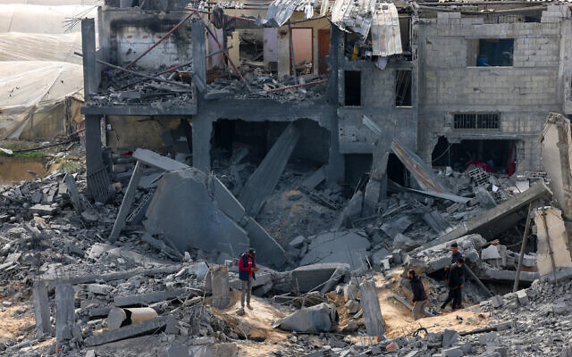 Palestinians inspect the damage on a building where two hostages were reportedly held before being rescued during an operation by Israeli security forces in Rafah, the southern Gaza Strip on February 12, 2024 (SAID KHATIB / AFP)