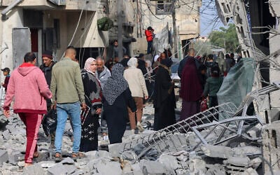 People inspect the damage in the rubble of buildings damaged during Israeli strikes in Rafah, in the southern Gaza Strip on February 12, 2024. (SAID KHATIB / AFP)