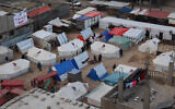 Displaced Palestinians stand outside their tents in Rafah in the southern Gaza Strip on February 14, 2024, amid the continuing battles  between Israel and Hamas. (Said Khatib/AFP)