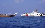 A handout picture released by the US Central Command (CENTCOM) on February 15, 2024, shows a US navy cutter next to a vessel reportedly carrying a shipment of Iranian weapons destined for Yemen's Houthi rebels which was seized on January 28. (CENTCOM/AFP)