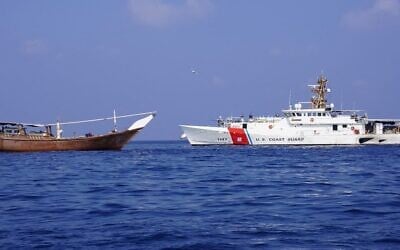 A handout picture released by the US Central Command (CENTCOM) on February 15, 2024, shows a US navy cutter next to a vessel reportedly carrying a shipment of Iranian weapons destined for Yemen's Houthi rebels which was seized on January 28. (CENTCOM/AFP)