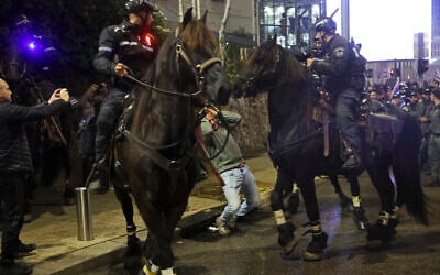 A demonstrator falls after being hit by a mounted police officer during an anti-government demonstration in Tel Aviv on February 24, 2024. (JACK GUEZ / AFP)
