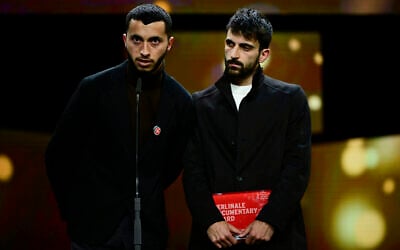 Palestinian director Basel Adra (L) and Israeli director Yuval Abraham on stage after having received the Berlinale documentary award for 'No Other Land' during the awards ceremony of the 74th Berlinale International Film Festival, on February 24, 2024, in Berlin. (John MacDougall/AFP)