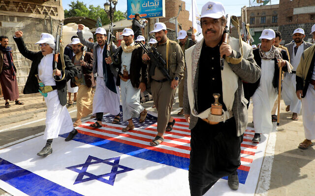 Members of the Iran-backed Houthi rebels march over Israeli and US flags painted on the street in Sanaa, Yemen, during a rally in support of Palestinians amid the Israel-Hamas in Gaza, February 28, 2024. (Mohammed Huwais/AFP) Members of the Iran-backed Houthi rebels march over Israeli and US flags painted on the street in Sanaa, Yemen, during a rally in support of Palestinians amid the Israel-Hamas in Gaza, February 28, 2024. (Mohammed Huwais/AFP)