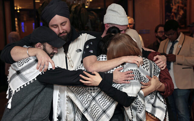 People hug at the Listen to Michigan watch party in Dearborn, Michigan on February 27, 2024 (JEFF KOWALSKY / AFP)