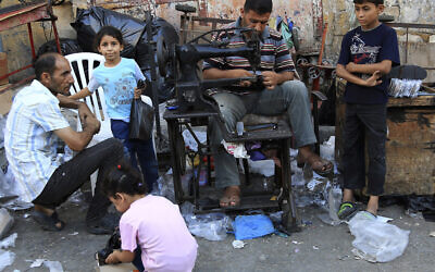Illustrative: A Palestinian man waits for a shoe repairman to fix his children's shoes before the upcoming Eid al-Fitr holiday to mark the end of the holy fasting month of Ramadan in Gaza City in the northern Gaza Strip on Thursday, July 16, 2015. (AP Photo/Adel Hana)