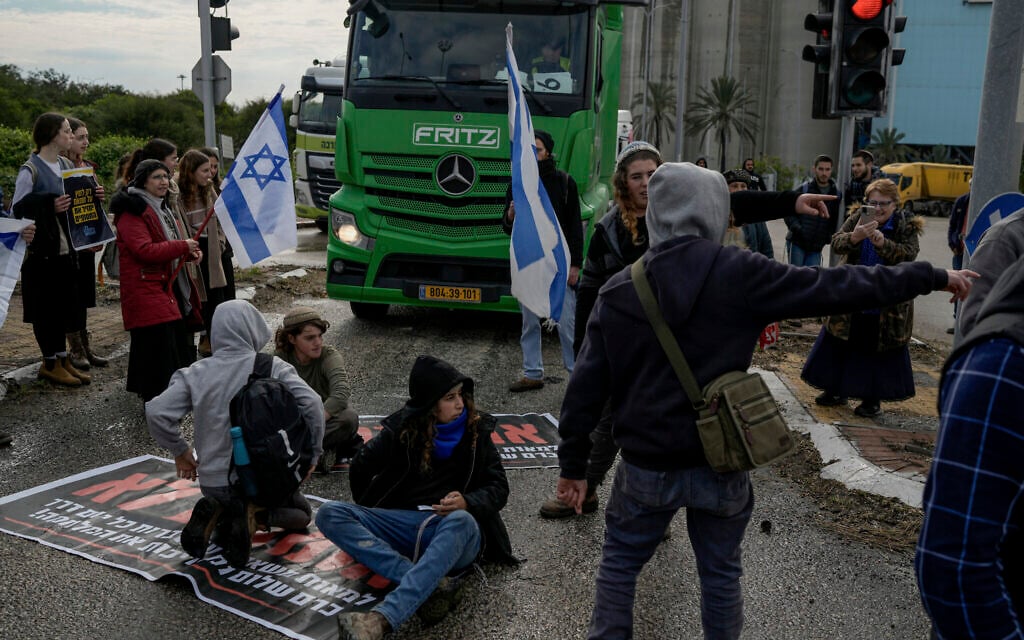 Israeli activists block the exit of Ashdod port to stop trucks they claim are carrying humanitarian aid destined for the Gaza Strip, in Ashdod, Israel, Thursday, Feb. 1, 2024. (AP/Leo Correa)