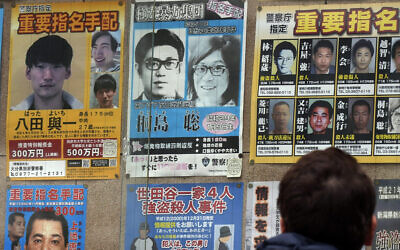 A wanted poster, center top. for Satoshi Kirishima, a fugitive who has long been wanted for one of a series of terrorist bombings in Japan, is displayed outside a police station Friday, Feb. 2, 2024, in Tokyo. (AP Photo/Eugene Hoshiko)