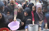 Illustrative: Palestinians line up for free food distribution in Khan Younis, Gaza Strip, February 2, 2024. (AP Photo/Hatem Ali)