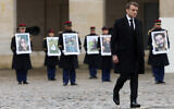French President Emmanuel Macron walks past French Republican Guards who hold portraits of the French victims of the Oct 7, 2023, Hamas onslaught in Israel, during a ceremony at the Invalides monument, Feb. 7, 2024 (Gonzalo Fuentes/Pool via AP)