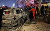 Civil defense members gather at the site of a burned vehicle targeted by a US drone strike in east Baghdad, Iraq, February 7, 2024. (AP Photo/Hadi Mizban)
