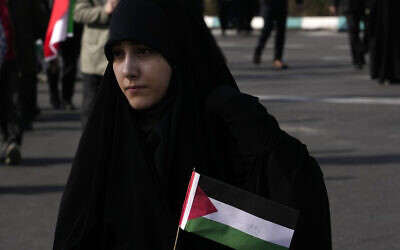 A woman carries a Palestinian flag in the annual rally commemorating Iran's 1979 Islamic Revolution in Tehran, Iran, February 11, 2024. (Vahid Salemi/AP)