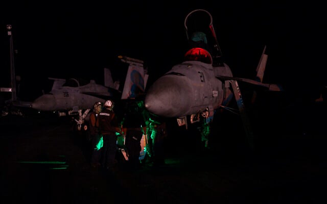 Aviation ordnance men work on the deck of the USS aircraft carrier Dwight D. Eisenhower, in the south Red Sea, February 14, 2024. (Bernat Armangue/AP)
