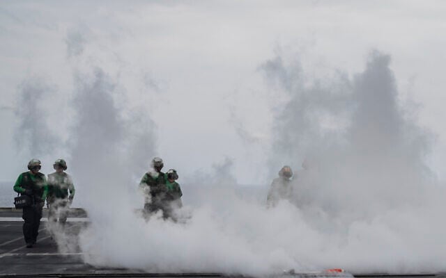 Crew walk the deck after takeoff of a fighter jet from the USS aircraft carrier Dwight D. Eisenhower, in the south Red Sea, February 13, 2024. (Bernat Armangue/AP)