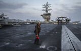 A crew member does maintenance work on the deck of the USS aircraft carrier Dwight D. Eisenhower, in the south Red Sea, February 13, 2024. (Bernat Armangue/AP)