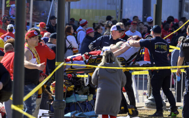 A woman is taken to an ambulance after an incident following the Kansas City Chiefs NFL football Super Bowl celebration in Kansas City, Missouri, Feb. 14, 2024. (AP Photo/Reed Hoffmann)