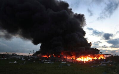 Black smoke and flames rise from a burning warehouse, hit by Israeli strikes, at an industrial district, in the southern coastal town of Ghazieh, Lebanon, February 19, 2024. (AP Photo/ Mohammed Zaatari)