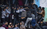 File: Palestinian crowds struggle to buy bread from a bakery in Rafah, Gaza Strip, February 18, 2024. (AP Photo/Fatima Shbair)