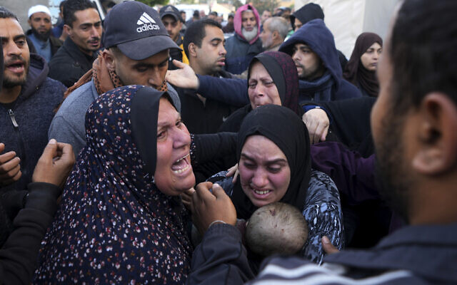 Palestinians mourn a baby killed in the Israel-Hamas war in front of the morgue of the Al Aqsa Hospital in Deir al Balah on Saturday, Feb. 24, 2024. (AP Photo/Adel Hana)
