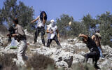 Illustrative: Israeli settlers hurl stones at Palestinians near the Israeli settlement of Yitzhar in the West Bank on October 7, 2020. (Nasser Ishtayeh/Flash90/File)