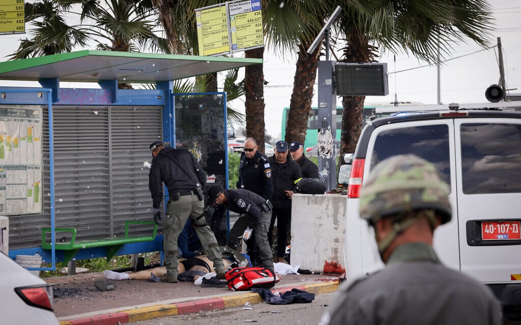 Israeli security forces seen near a terrorist who was killed at the scene of a shooting attack in Southern Israel. February 16, 2024. (Nati Shohat/FLASH90)