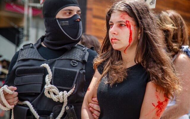 Actress Alessandra Dayan is pulled through the streets of Sao Paulo, Brazil, in a graphic reenactment of the real-life abduction of Naama Levy by Hamas terrorists, November 30, 2023. (Abner Palma/Fisesp)