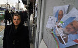 A woman walks past electoral posters of Ayatollah Alireza Arafi, a candidate for the upcoming Assembly of Experts elections in downtown Tehran, Iran, February 21, 2024. (AP Photo/Vahid Salemi)