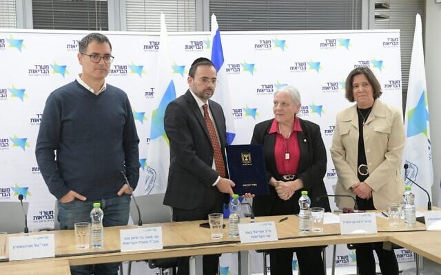 Health officials at the announcement of the 2024 health basket recommendations. The center three are (left to right): Health Ministry Director-General Moshe Bar Siman Tov, Health Minister Uriel Busso, and health basket committee chair Prof. Dina Ben-Yehuda, February 22, 2024. (Courtesy of Health Ministry) Health officials at the announcement of the 2024 health basket recommendations. The center three are (left to right): Health Ministry Director-General Moshe Bar Siman Tov, Health Minister Uriel Busso, and health basket committee chair Prof. Dina Ben-Yehuda, February 22, 2024. (Courtesy of Health Ministry)