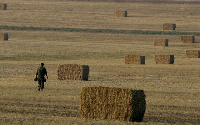 An IDF soldier in a field next to Kibbutz Mefalsim. (AFP photo/ Yoav Lemmer)