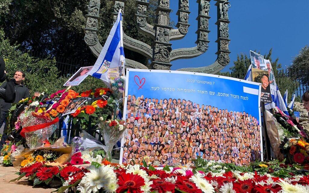 Mourning families place photos of their loved ones murdered in Supernova massacre alongside flower bouquets outside the Knesset in Jerusalem on February 7, 2024. (Charlie Summers/Times of Israel)