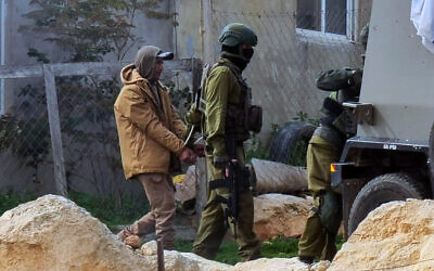 Palestinian artist Eid Suleiman Hthaleen is handcuffed and taken away for questioning by IDF soldiers in the Palestinian village of Umm al-Khair, February 14, 2023. (Courtesy)