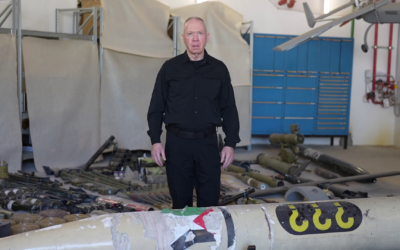 Defense Minister Yoav Gallant gives a video statement from a display of Hamas weapons and intelligence findings found by troops in the Gaza Strip, at the Julis Base, February 11, 2024. (Elad Malka/Defense Ministry)