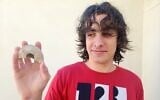 Teen Yonatan Frankel and the 1,600-year-old Roman oil lamp he discovered while hiking, in an undated photo. (Yoli Schwartz/IAA)