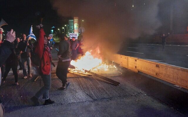 Protesters light a bonfire on Tel Aviv's Ayalon Highway, March 23, 2024. (Iddo Schejter)
