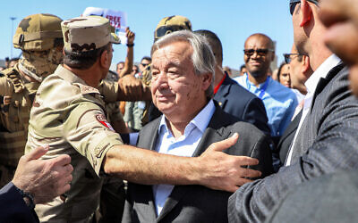 Illustrative: Protesters raise signs in solidarity with Palestinians in the Gaza Strip as Egyptian army officers and bodyguards escort UN Secretary-General Antonio Guterres to his vehicle, during a visit to oversee preparations for the delivery of humanitarian aid to the Palestinian enclave, on the Egyptian side of the Rafah border on October 20, 2023. (Kerolos Salah/AFP)