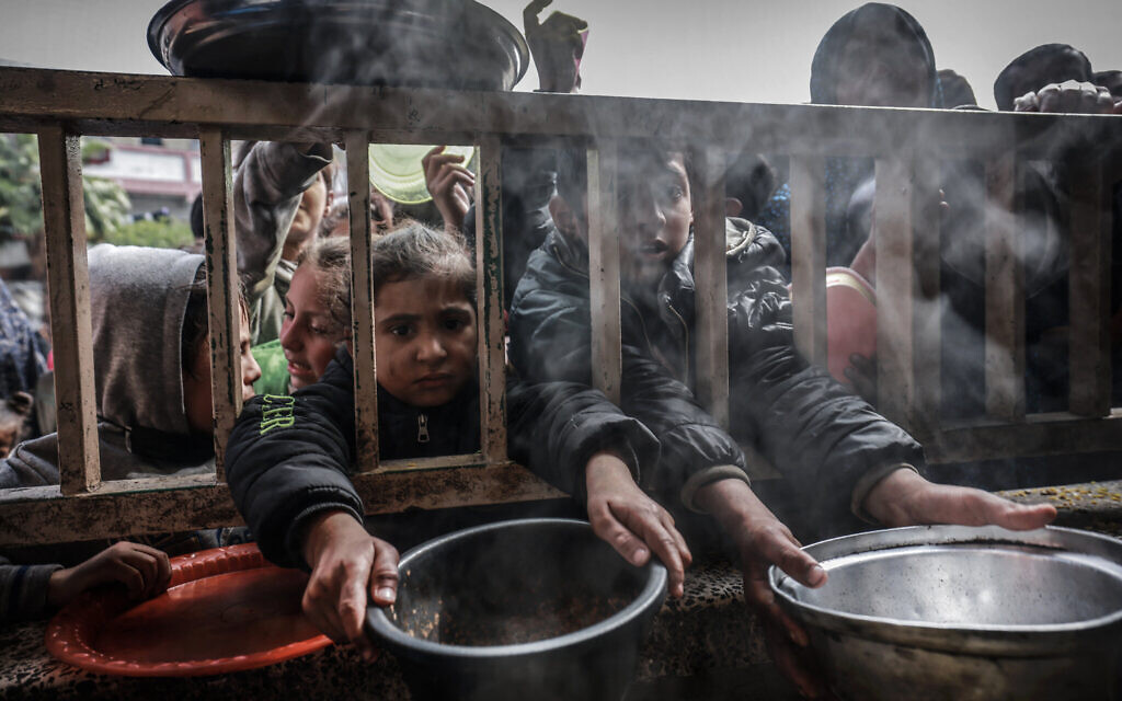 Displaced Palestinian children gather to receive food at a government school in Rafah in the southern Gaza Strip on February 19, 2024. (Mohammed Abed/AFP)