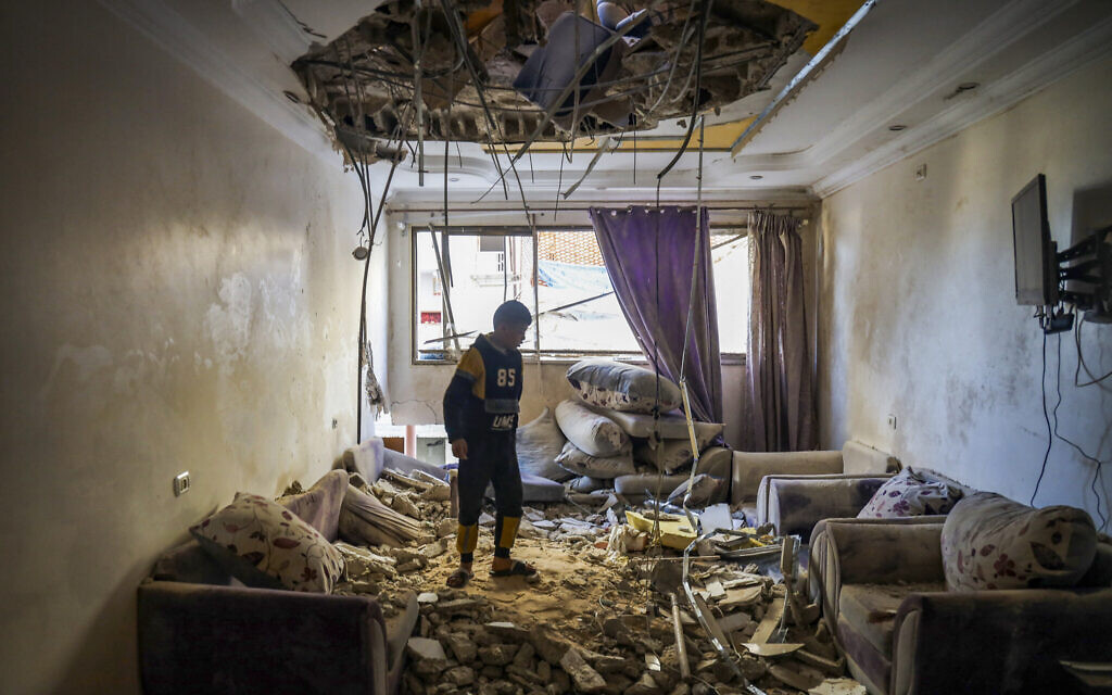 A Palestinian child stands in the living room of a building that was damaged during Israeli strikes in Rafah, on the southern Gaza Strip, on March 2, 2024 (AFP)