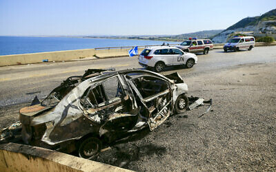 A UNIFIL (the United Nations Interim Force in Lebanon) patrol drives past the wreckage of a car that was targeted in an Israeli strike on March 2, 2024, near the southern Lebanese town of Naqoura. (AFP)