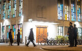 Police officers stand guard at the Synagoge Agudas Achim in Zurich, on March 3, 2024, after an Orthodox Jewish man was stabbed, late on March 2, 2024. (Arnd Wiegmann/AFP)