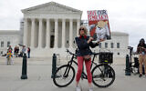 Local resident Nicky Sundt holds a sign that reads 'Save Our Democracy,' in front of the US Supreme Court on March 4, 2024, in Washington, DC. (Alex Wong/ Getty Images/ AFP)