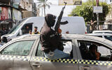 Armed members of the "People's Protection Committees" patrol the streets of Gaza's southern city of Rafah on March 6, 2024. (Said Khatib/AFP)