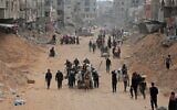 Displaced Palestinians carry their belongings through a street in Khan Yunis in the southern Gaza Strip on March 6, 2024, amid the ongoing conflict between Israel and Hamas. (AFP)