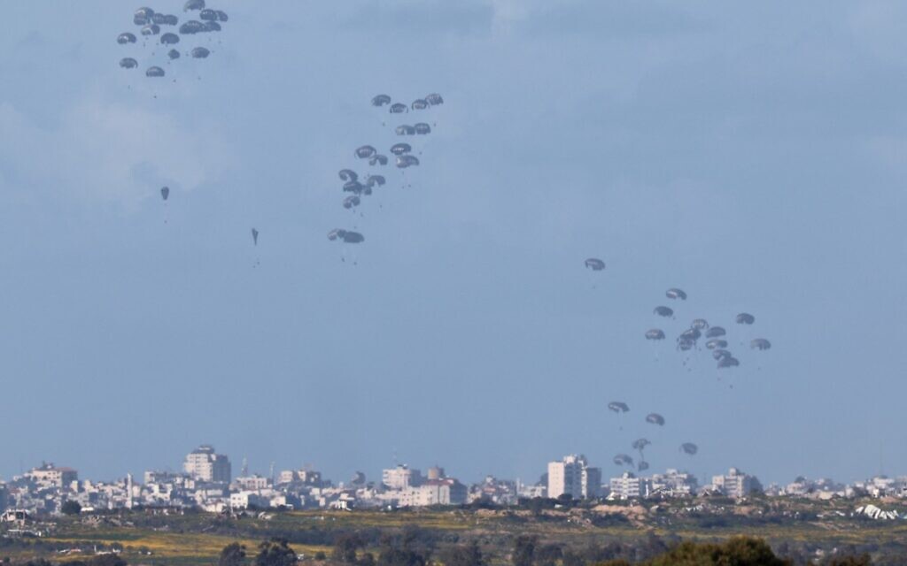 Humanitarian aid falls over northern Gaza as seen from Israel's southern border with the Gaza Strip on March 7, 2024. (JACK GUEZ / AFP)