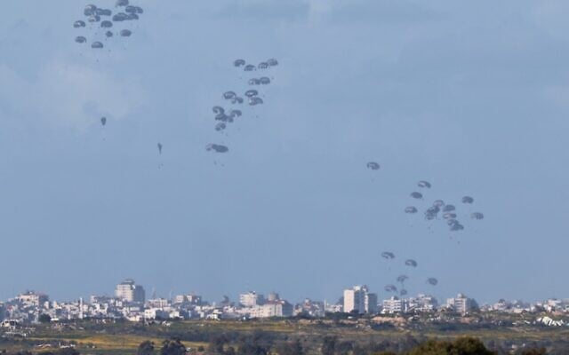 Humanitarian aid falls over northern Gaza as seen from Israel's southern border with the Gaza Strip on March 7, 2024. (JACK GUEZ / AFP)