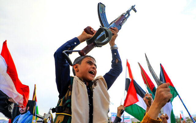 A Yemeni youth brandishes a weapon people march in the Houthi-run capital Sanaa on March 8, 2024, in support of Palestinians amid ongoing battles between Israel and the Hamas in the Gaza Strip. (Photo by MOHAMMED HUWAIS / AFP)