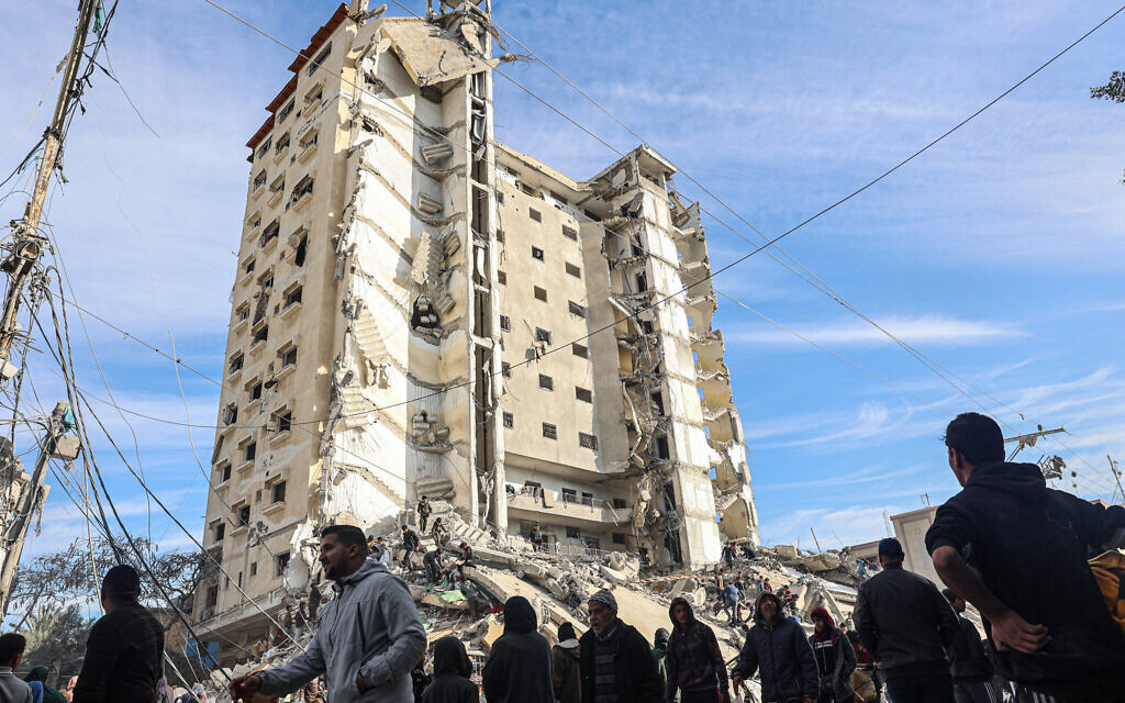 Palestinians gather in front of a residential building hit in an overnight Israeli air strike in Rafah in the southern Gaza Strip on March 9, 2023. (Said Khatib/AFP)