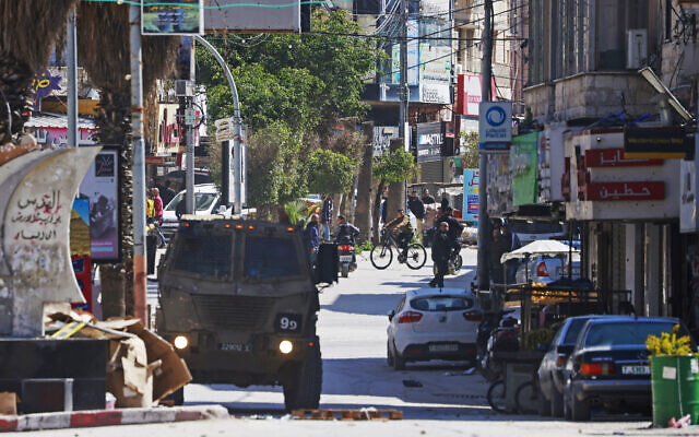 An Israeli military vehicle patrols along a street during a raid at the Jenin refugee camp area in the West Bank on March 12, 2024. (Photo by Jaafar ASHTIYEH / AFP) An Israeli military vehicle patrols along a street during a raid at the Jenin refugee camp area in the West Bank on March 12, 2024. (Photo by Jaafar ASHTIYEH / AFP)