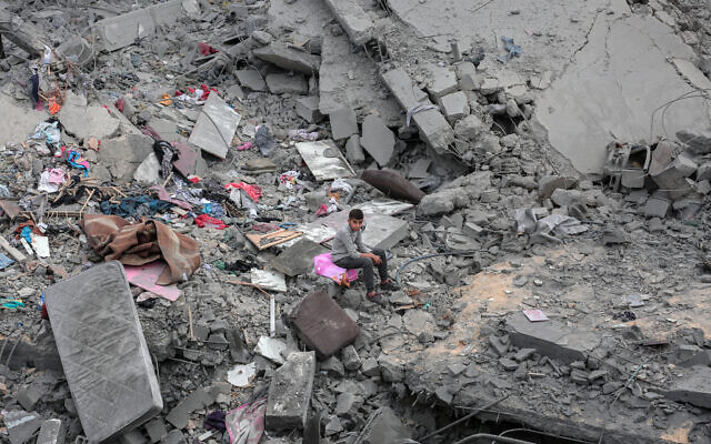 A Palestinian boy sits among rubble in Deir el-Balah in the central Gaza Strip on March 13, 2024. (AFP) A Palestinian boy sits among rubble in Deir el-Balah in the central Gaza Strip on March 13, 2024. (AFP)