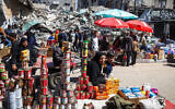 Palestinians walk at a makeshift market next to building rubble during the Muslim holy fasting month of Ramadan in Rafah in the southern Gaza Strip on March 12, 2024. (AFP)